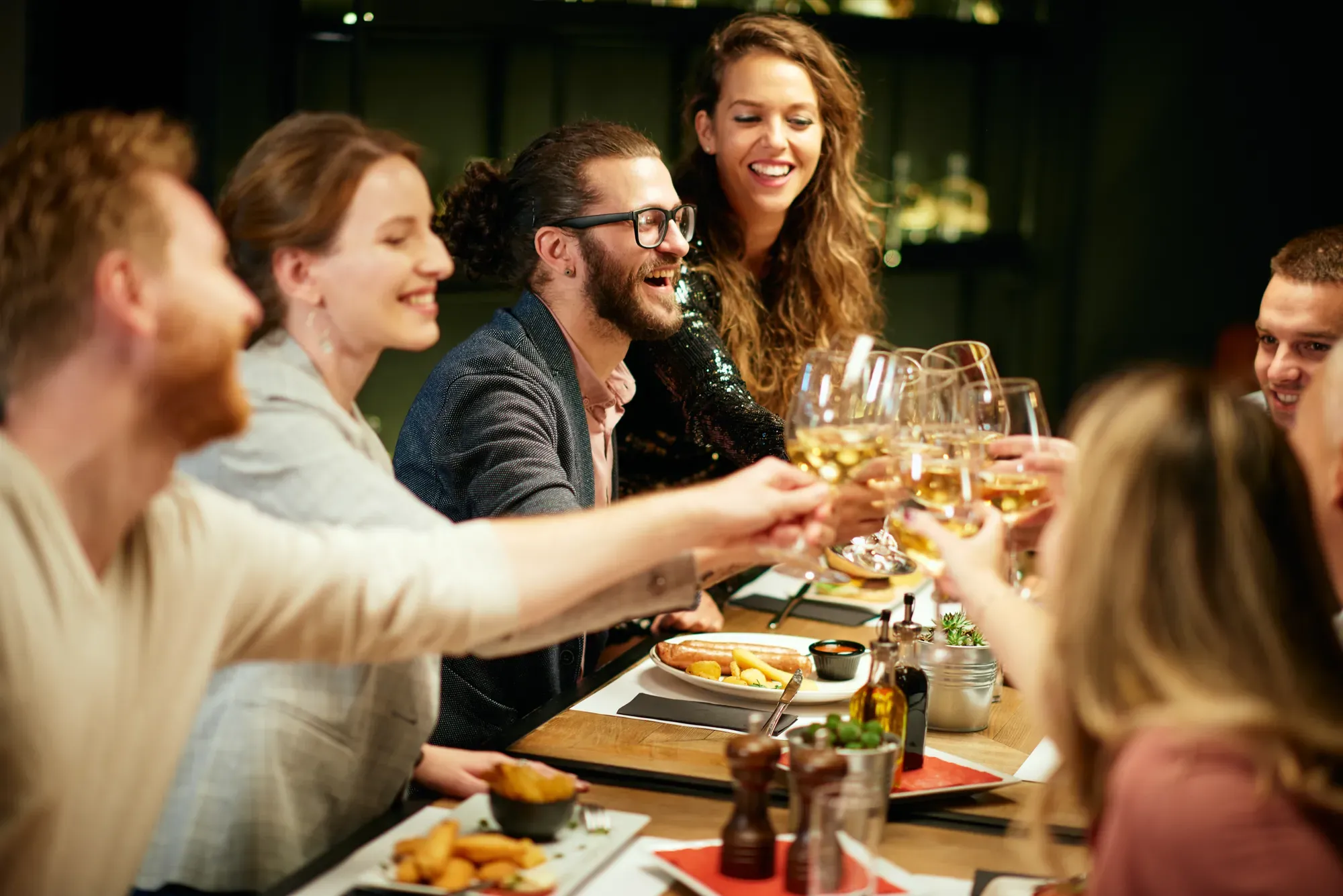Friends raising glasses around a dinner table