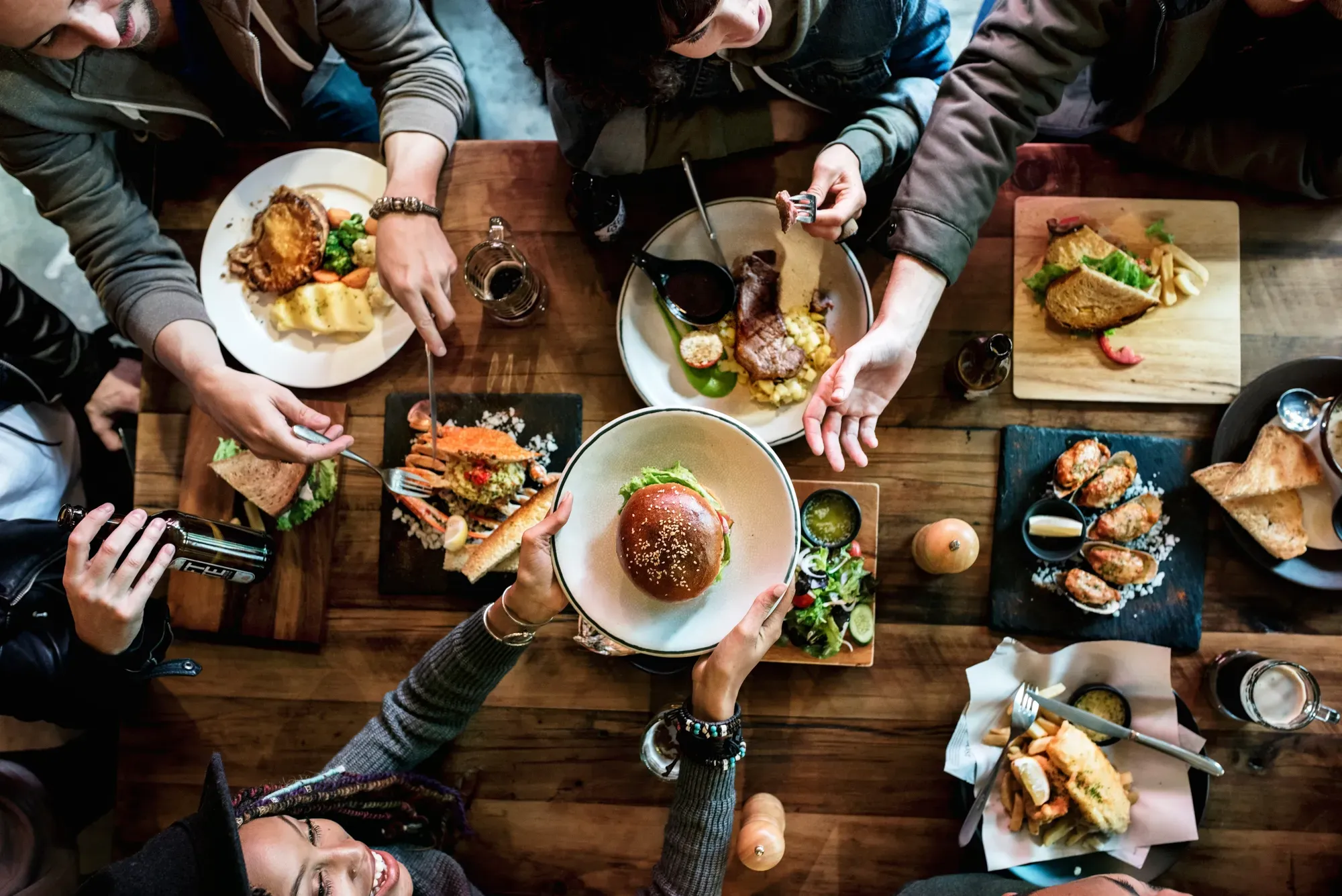 Friends sharing plates around a wooden table